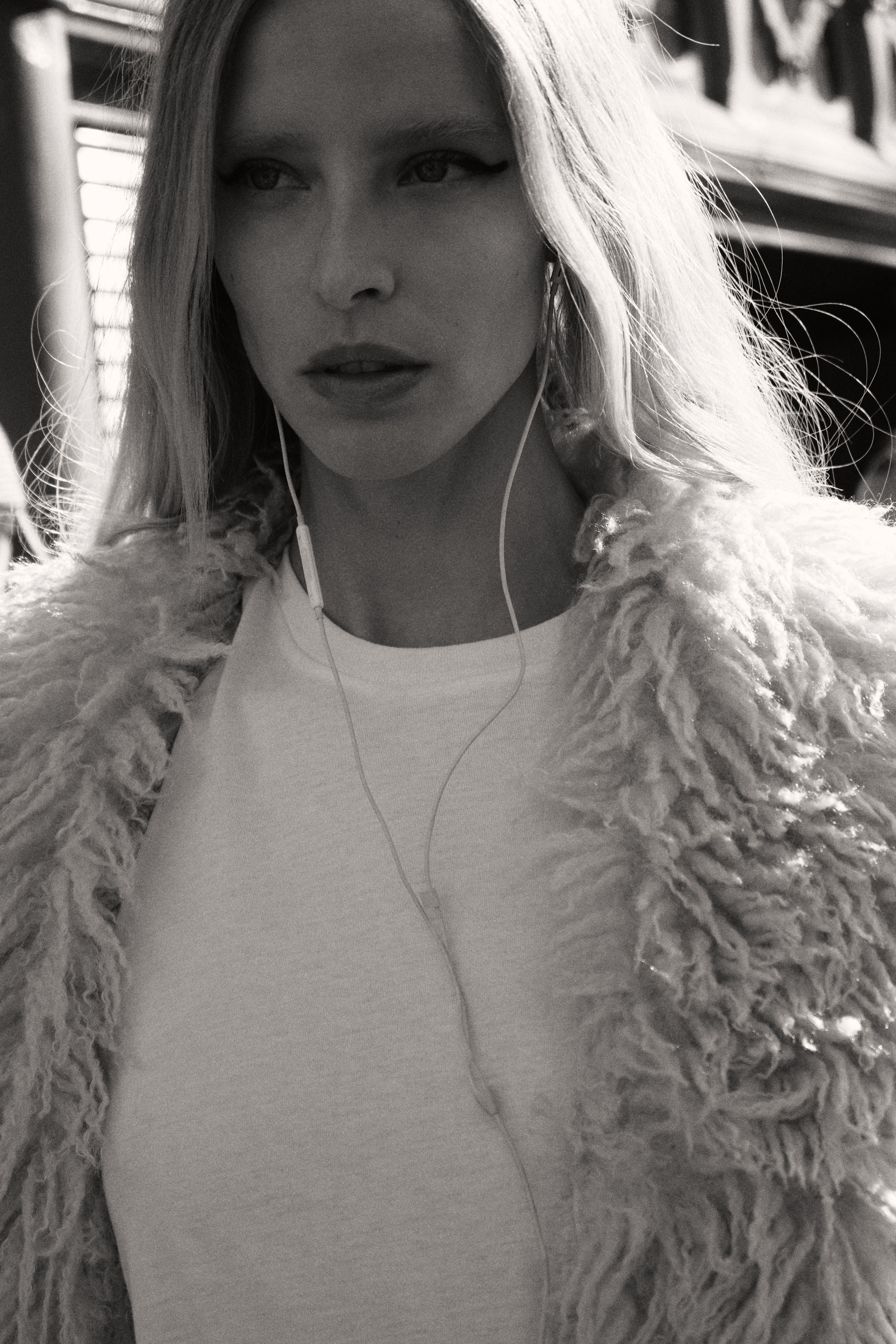 Blonde model in fluffy coat with earbuds