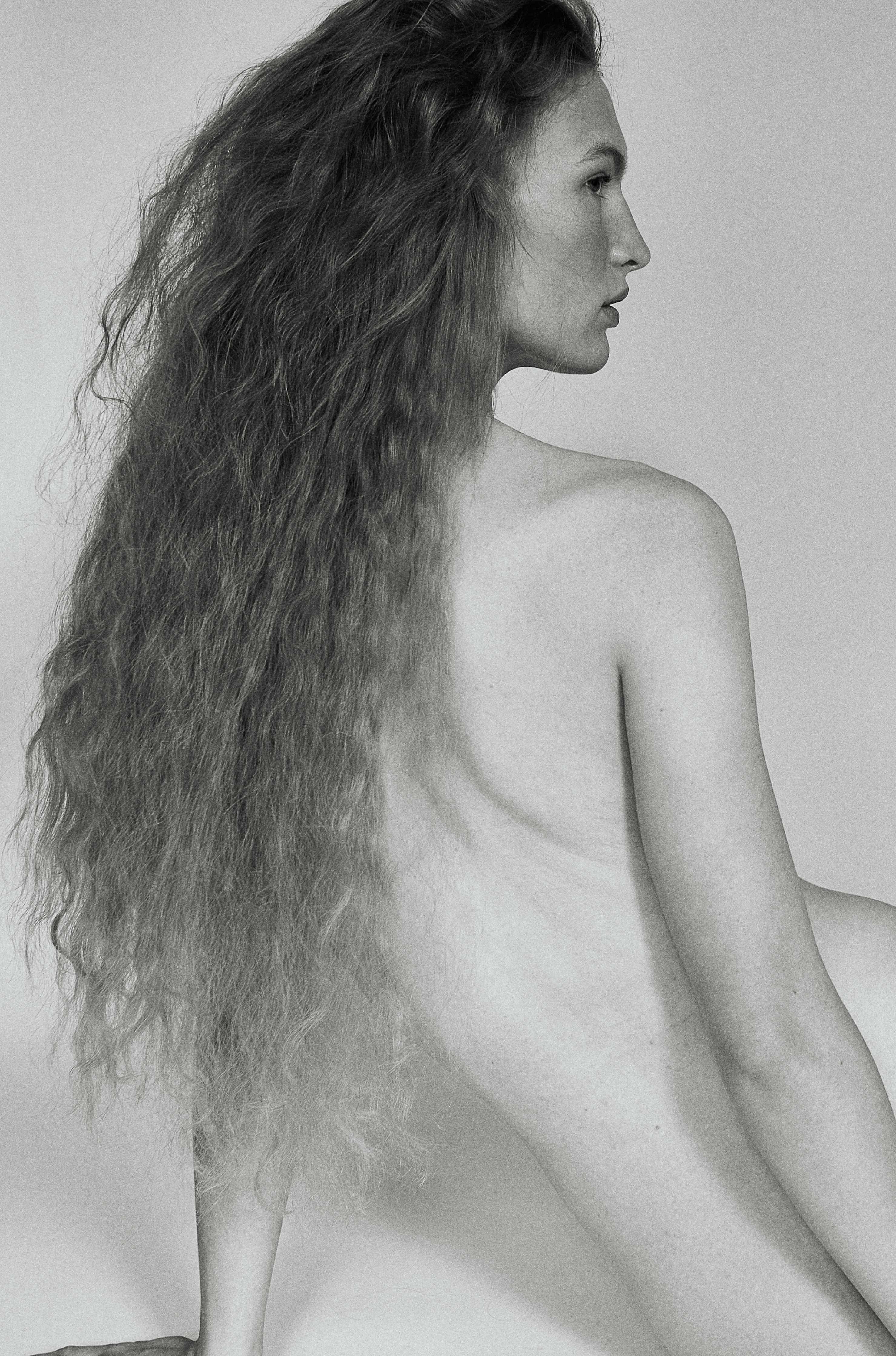 Black and white profile model with long curly hair