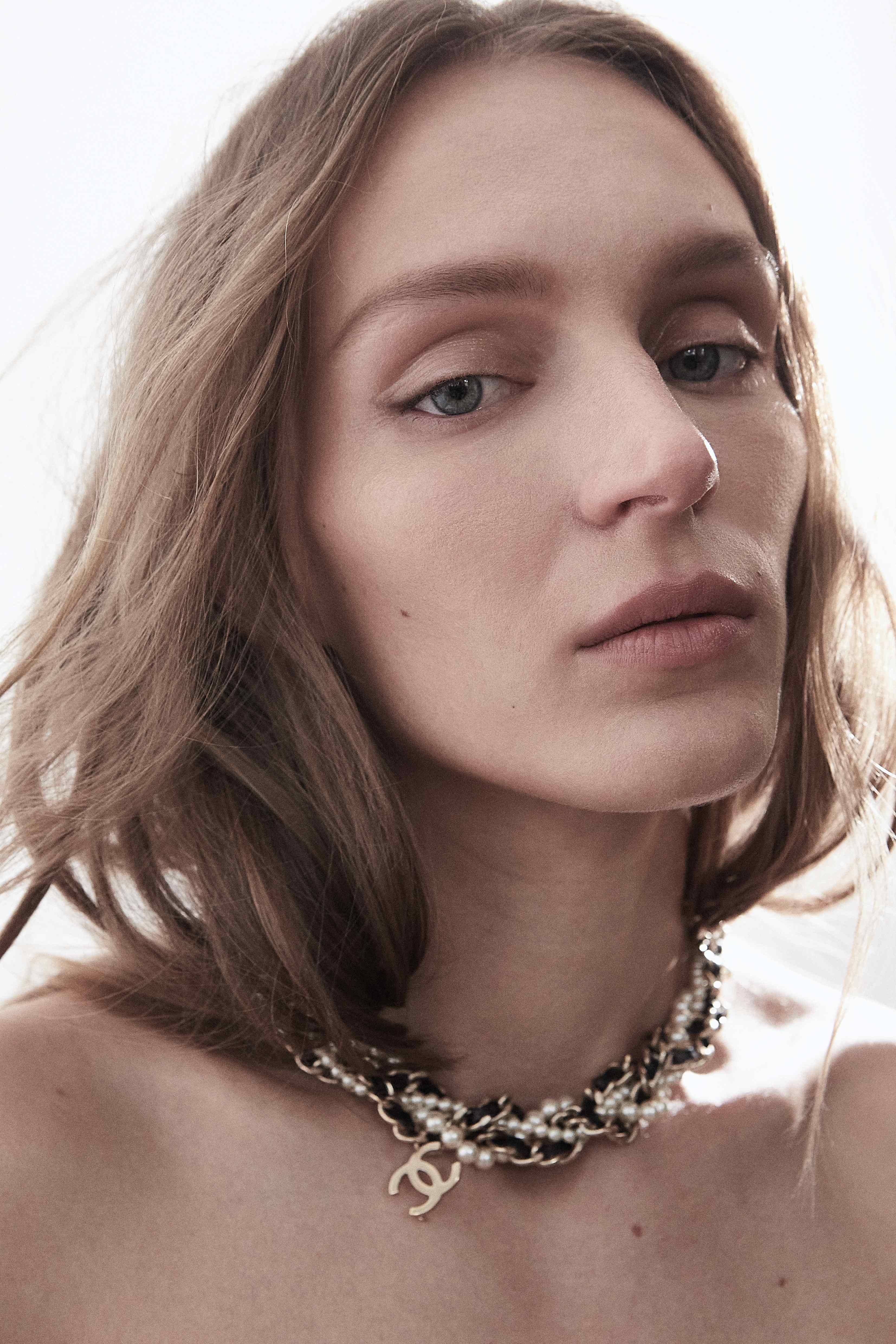 Front beauty shot with Chanel pearl necklace