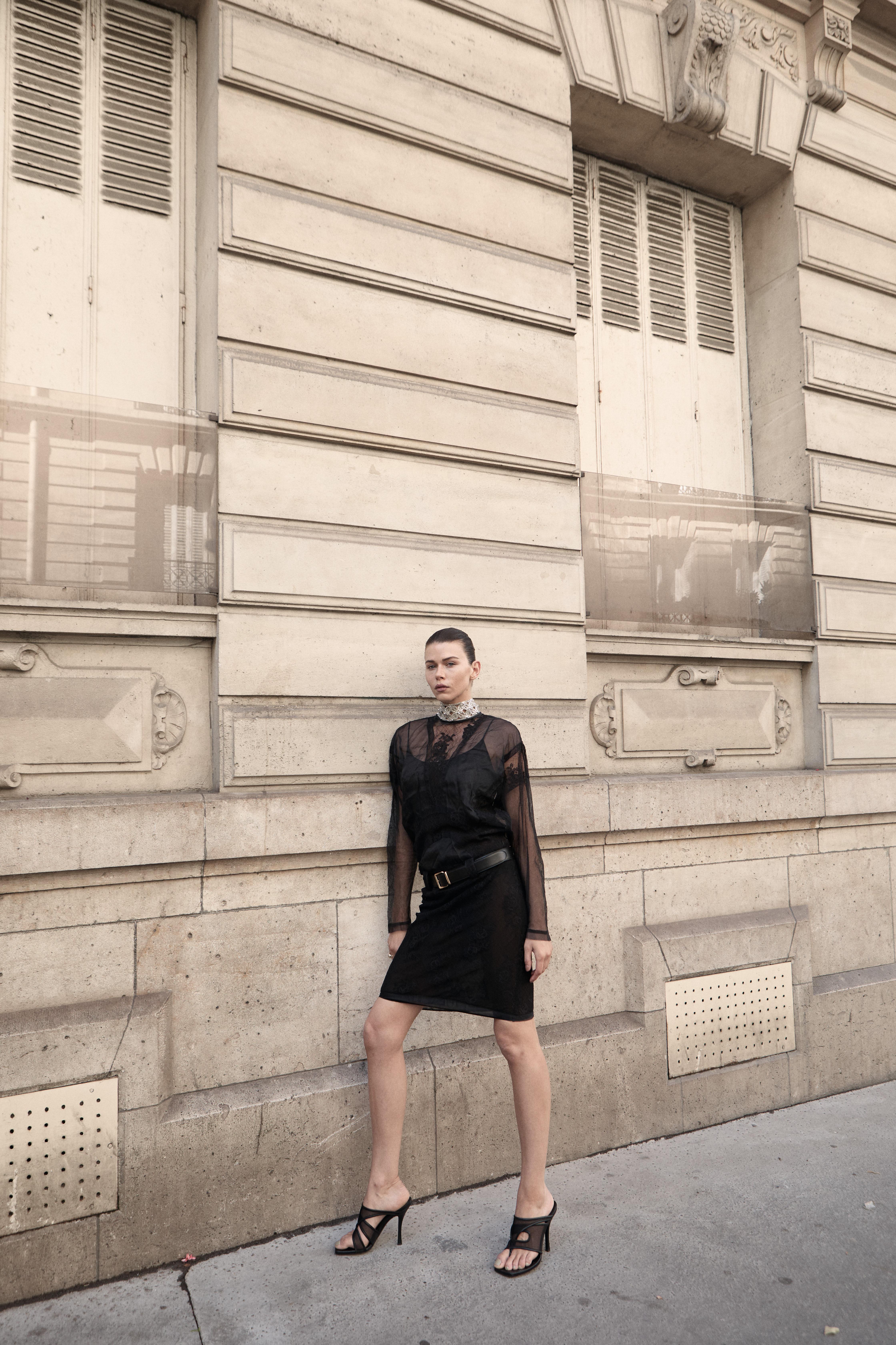 Model in black sheer dress sequin collar Paris building