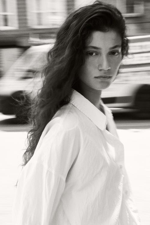Black and white portrait with long dark hair over shoulder