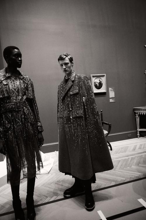 Black and white gallery scene with two models in sequined coats